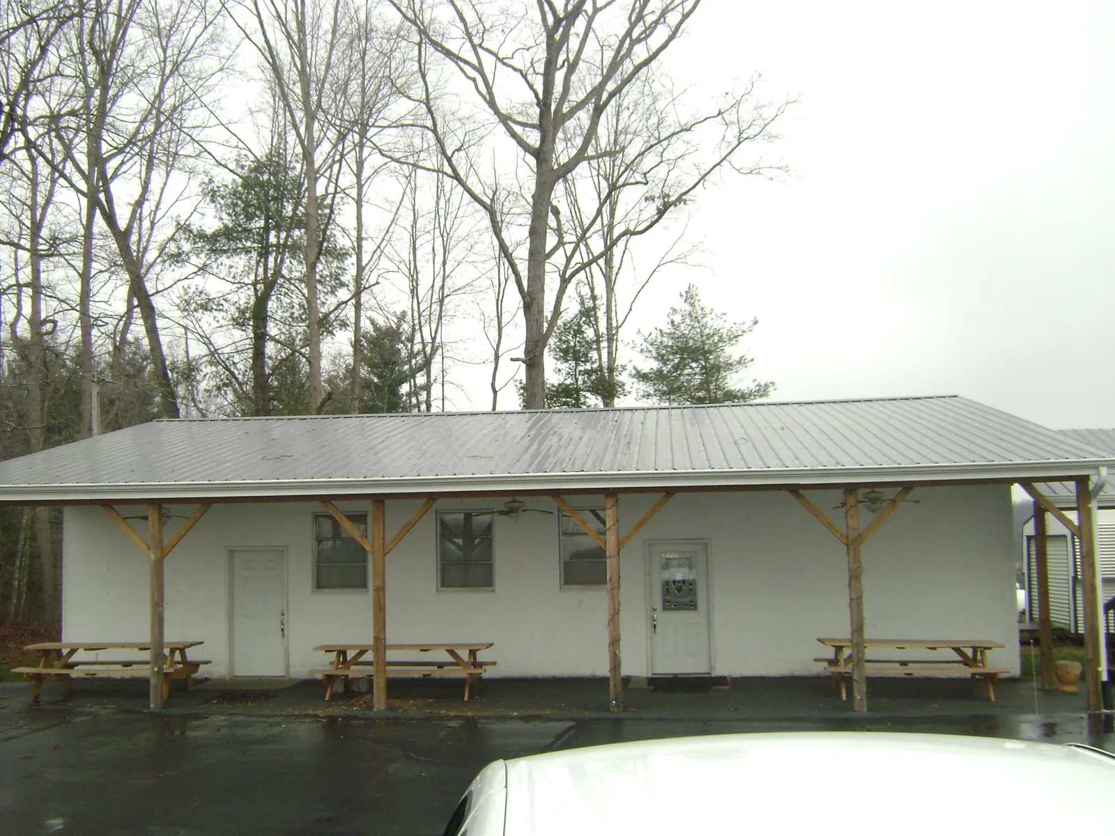 Gray metal roof over a block building with a timber post porch in Farmington